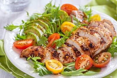 Healthy salad plate with tomatoes, chicken breast and avocado