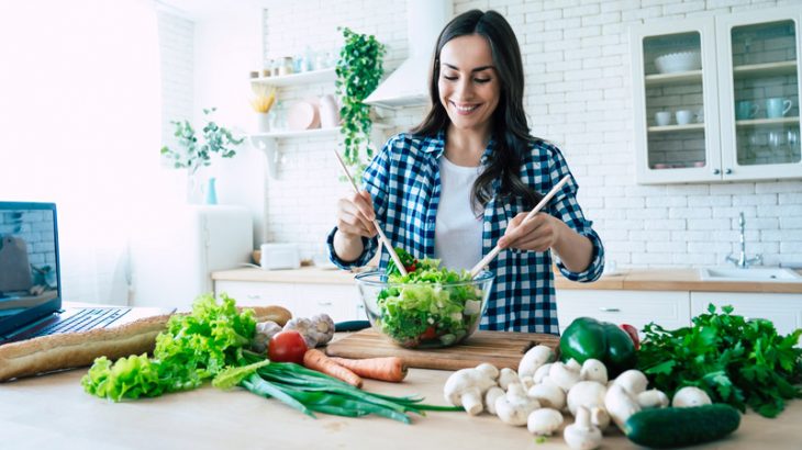 Young woman preparing vegetable salad